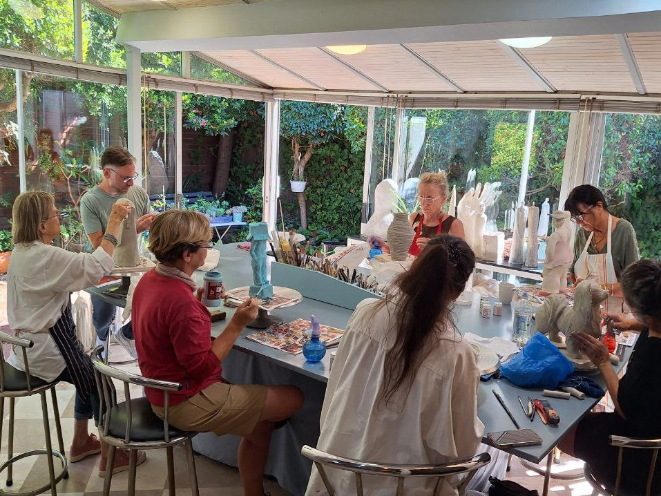 Sculpting Class students working around the teaching table in Alán Nabavi's studio