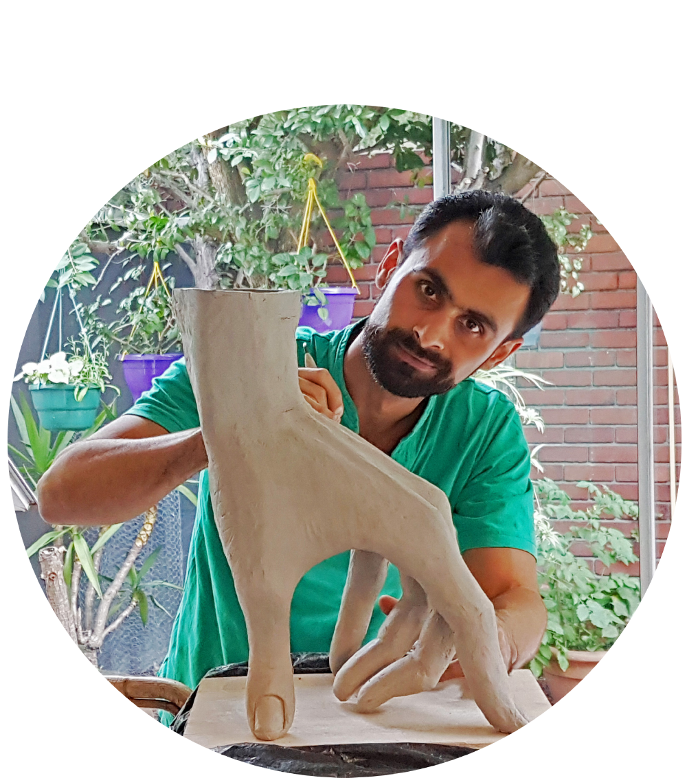 Alan Nabavi artist, sculptor, painter in his studio working on a ceramic hand sculpture