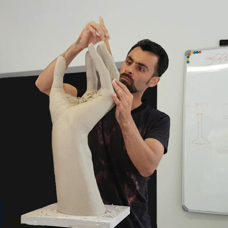 Alan Nabavi in his studio working on a large format cupped ceramic hand